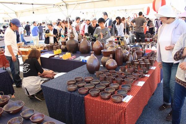 テントの中に様々な形の丹波焼陶器が並んでおり、それを見ている人々の写真